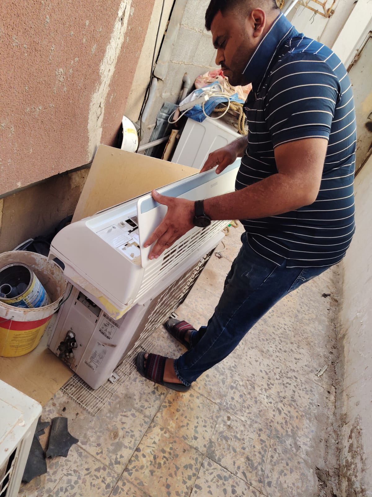 فني صيانة تكييف بتبوك أثناء فحص الوحدة
